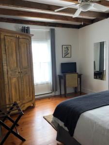 - une chambre avec un lit, une commode et un bureau dans l'établissement AUBERGE Knowlton, à Lac-Brome