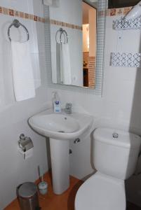 a bathroom with a sink and a toilet and a mirror at Casa Roque in Telde