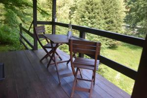 einen Holztisch und zwei Stühle auf einer Veranda in der Unterkunft Sommerhaus Bella Vita in Bad Schandau