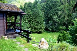 eine Hütte mit einer Veranda auf einem Feld mit Bäumen in der Unterkunft Sommerhaus Bella Vita in Bad Schandau