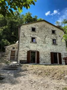 een oud stenen gebouw met deuren en ramen bij Casina del Ponte in Bagno di Romagna