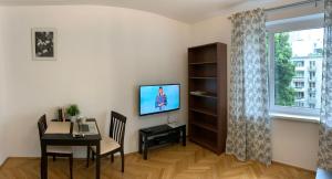 ワルシャワにあるZłota 81のリビングルーム(テーブル、テレビ、窓付)