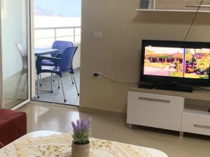 a living room with a tv and a table with chairs at Premium Apartaments 02-03 in Vlorë