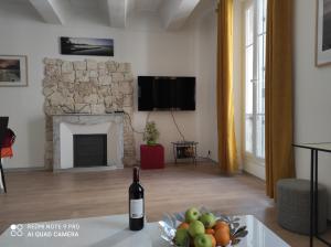 ein Wohnzimmer mit einer Flasche Wein und einer Schale Obst in der Unterkunft Suite Française Old Town in Antibes
