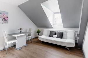 a living room with a white couch and a table at Comfort Stay Basel Airport 3B46 in Saint-Louis