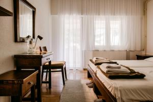 1 Schlafzimmer mit 2 Betten, einem Schreibtisch und einem Spiegel in der Unterkunft Restoran sa prenoćištem Gornjak in Krepoljin