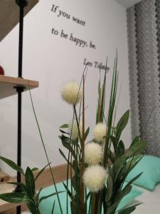 un jarrón de flores con una señal que diga si quieres ser feliz en Mateja Apartment, en Novi Sad
