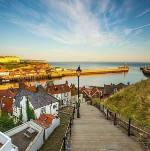 een loopbrug naast een waterlichaam met een pier bij Cottages-Whitby in Whitby