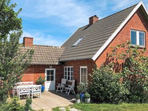 a red brick house with a table and chairs at Three-Bedroom Holiday home in Gudhjem 2 in Gudhjem