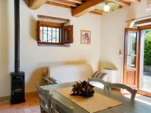 una sala da pranzo con tavolo e stufa a legna di Apartment in a holiday home in Anghiari with a view of the hills a Galbino