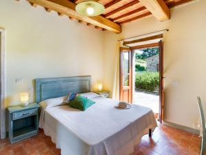 una camera con letto e porta di accesso a un patio di Apartment in a holiday home in Anghiari with a view of the hills a Galbino