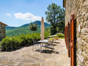 GalbinoにあるApartment in a holiday home in Anghiari with a view of the hillsのパティオ(テーブル、パラソル、椅子付)