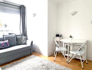 ein Wohnzimmer mit einem Sofa und einem Tisch in der Unterkunft Elegant Fitzrovia 2-bed w Wifi: Close to Oxford Street W1 in London