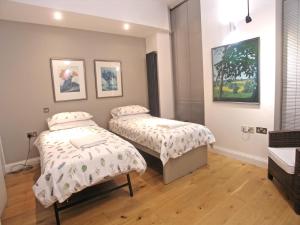 two beds in a room with paintings on the wall at Saint Anns in London