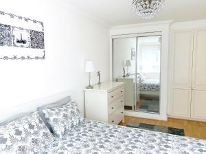 a white bedroom with a bed and a mirror at Elegant Fitzrovia 2-bed w Wifi: Close to Oxford Street W1 in London