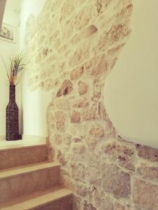 a stone wall with a vase sitting on a shelf at Flavì in Bari