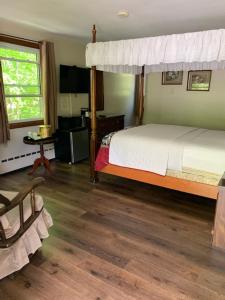 1 dormitorio con cama con dosel y suelo de madera en Stay Berkshires en Williamstown