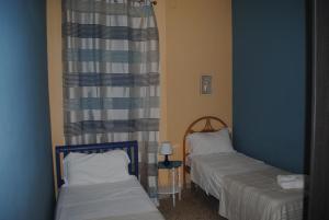 a room with two beds and a curtain at Summer Beach Rooms in Fontane Bianche