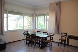 a dining room with a table and chairs and windows at Summer Beach Rooms in Fontane Bianche