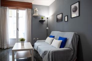 ein Wohnzimmer mit einem Sofa und einem Tisch in der Unterkunft TuristiQA - Piso C Arenal 20 2º VUT-CO-01678 in Ferrol