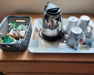 Mount Stuart Hotel في بورنموث: وعاء الشاي على صينية مع سلة على طاولة