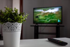 un mando a distancia sentado en una mesa junto a una TV en TuristiQA - Piso C Arenal 20 2º VUT-CO-01678, en Ferrol