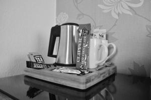 una mesa con una cafetera y tazas en ella en Tregorran Guest House Mevagissey, en Mevagissey