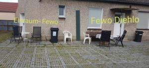 a group of chairs and tables in front of a building at Einraum-Ferienwohnung 46m2 Eisenhüttenstadt-Diehlo in Eisenhüttenstadt