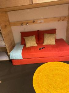 a bed in a small room with a red couch at Cosy Apartment Tara Edelweiss at Skiing Resort of Falls Creek in Falls Creek