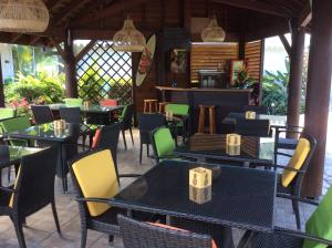 ein Restaurant mit Tischen und Stühlen und eine Bar in der Unterkunft Relais Fenua in Punaauia