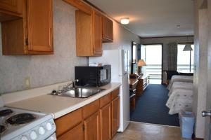 a kitchen with a sink and a microwave and a room at Blue Heron Motel in Nags Head