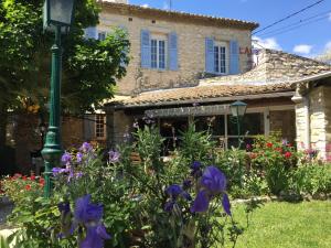 un giardino di fronte a una casa con fiori viola di Logis Auberge De Tavel a Tavel