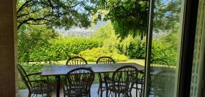 una mesa de madera con 4 sillas y una ventana en Agriturismo Tognoloni en Gubbio