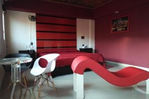 a bedroom with a red bed with a red accent wall at Hotel Quinta Tlalpan in Mexico City