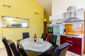 a dining room with a table and chairs and a kitchen at Apartments Melita in Trogir +48 photos