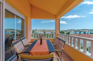 a porch with a table and chairs on a balcony at Apartments Melita in Trogir