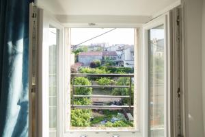 a window with a view of a city at Appartement Le P'tit Dupont - OscarNewHome in Nancy