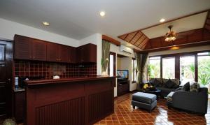 eine Küche und ein Wohnzimmer mit einem Sofa und einer Theke in der Unterkunft Bhumlapa Garden Resort in Bophut 