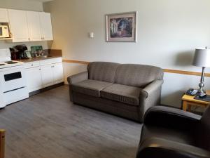 a living room with a couch and a kitchen at Lakeview Motel & Suites in Osoyoos