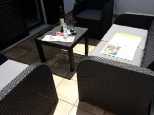 una sala de estar con 2 sillas y una mesa con una botella de vino en Familia Brito en Porches