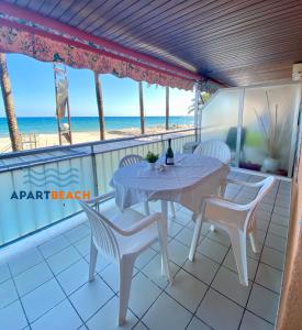 una mesa y sillas en un balcón con vistas a la playa en APARTBEACH AGUSTINA ARAGON CLIMATIZADO y VISTAS PLAYA, en Salou