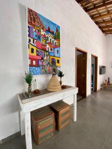 a painting on the wall of a room with a table at BEM ESTAR À BEIRA MAR in Ubatuba