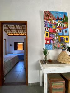 a room with a bed and a painting on the wall at BEM ESTAR À BEIRA MAR in Ubatuba