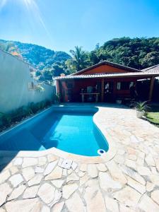 a swimming pool in front of a house at BEM ESTAR À BEIRA MAR in Ubatuba