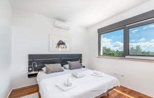 Un dormitorio blanco con una cama grande y una ventana. en Villa Laura Istarska, en Višnjan 38 fotos más