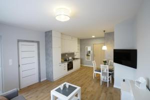 a living room with a kitchen and a dining room at Apartament na Wspólnej ( centrum, garaż ) in Kielce