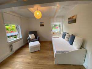 a bedroom with a bed and a couch and a chair at Ferienwohnung Alte Schmiede in Wangerland