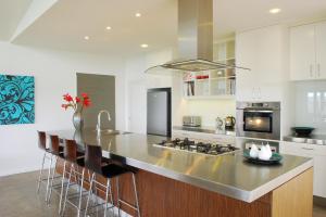 a kitchen with a large island with bar stools at The Ridge Gloucester in Gloucester