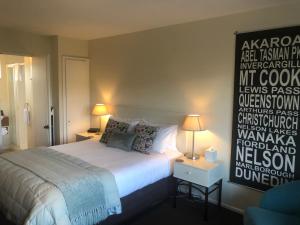 een slaapkamer met een bed en een bord aan de muur bij Tuscana Motor Lodge in Christchurch