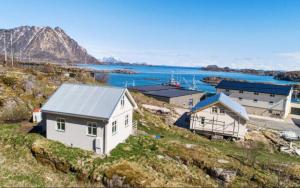 SkaftnesetにあるRagnahuset - Koselig minihus i fiskeværの水の横の丘の上の家 +2枚の写真